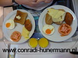 Een foto van ons ontbijt. Croissantje, broodje, ei, kaas, tomaat en sinasappelsap.